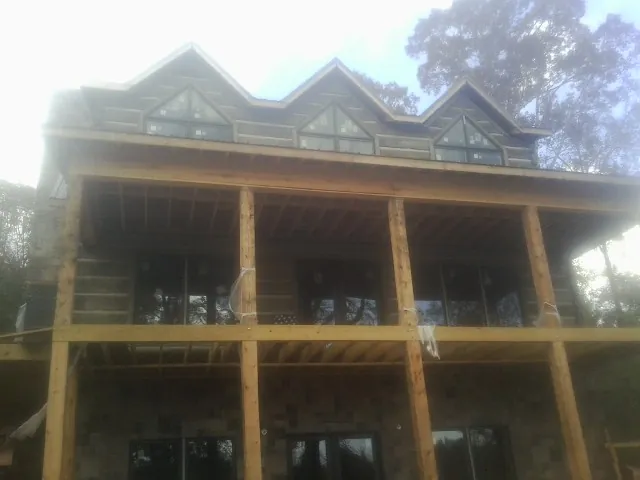 Dormers and porch framing on a large log home under construction — Roof Coating work by our crew in Culpeper